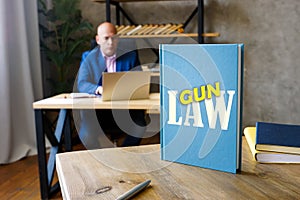 Lawyer holds LAWS GUN book. Gun control is one of the most divisive issues in AmericanÃÂ politics photo